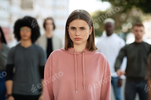 Preview: Indignant young lady standing over multiracial group of students