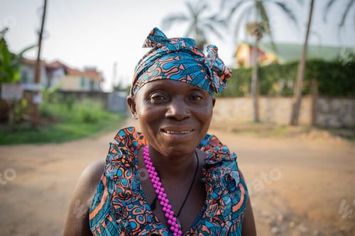 Preview: Portrait of a smiling middle aged african woman outside outdoors.