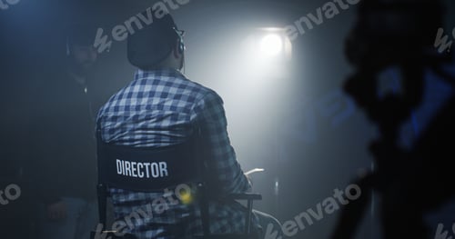 Preview: Medium Shot Of A Director Sitting In His Chair On A Film Set