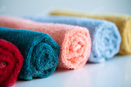 Preview: Colored towels on white table with copy space on bath room background.