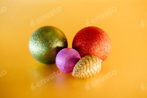 Preview: Colorful christmas balls on the yellow table. Beautiful merry Christmas decorations on table.