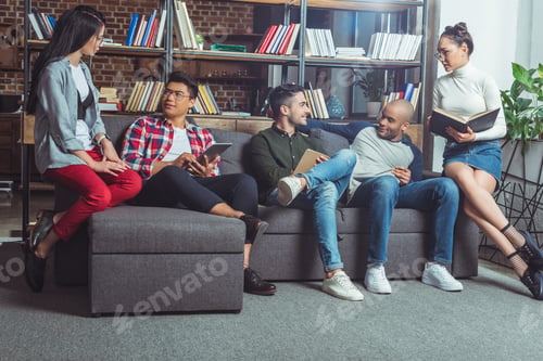 Preview: group of young multiethnic friends studying together indoors