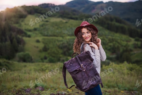 Preview: Young tourist woman traveller with backpack walking in nature