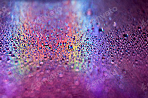 Preview: Selective focus shot of colorful reflective water drops on a digital disc surface