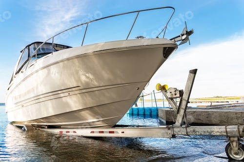 Preview: Big luxury cabin motorboat cruiser yacht launching at trailer ramp on river or lake.