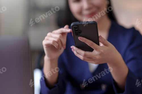 Preview: Smiling and attractive Asian woman using smartphone to play social media applications