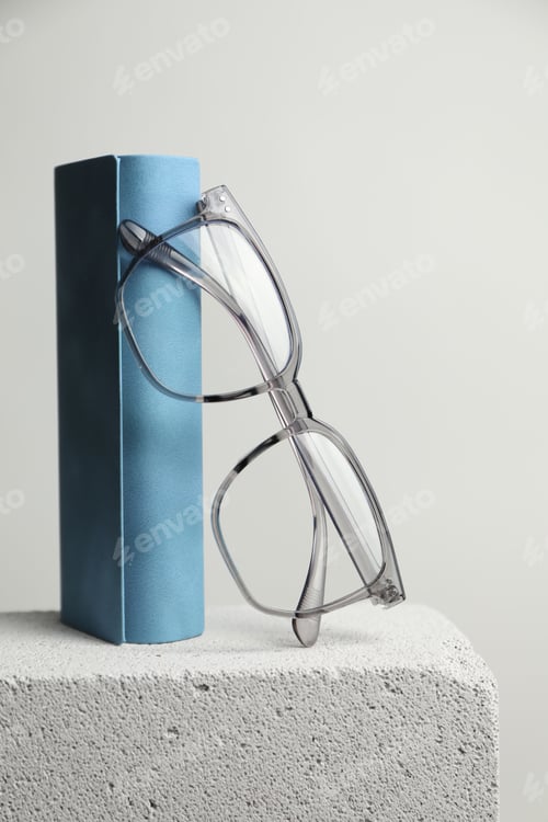 Preview: Stylish glasses and case on stone surface against light grey background