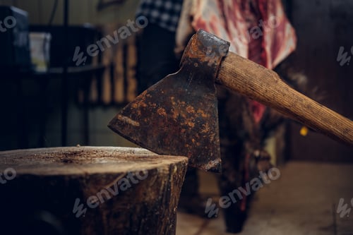 Preview: Close up image of axe over bearded butcher on background.