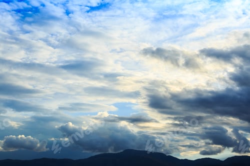 Preview: Mountain range with blue sky and heavy clouds.