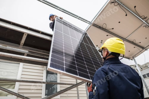 Preview: Workers installing solar panel on house roof using scaffolding