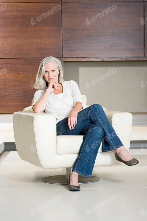 Preview: Elegant woman relaxing in a modern armchair