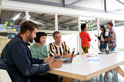 Preview: Diverse business people discussing over laptop and sticky notes in the conference room