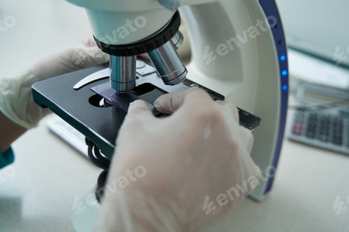 Preview: Woman laborant doing tests with microscope in clinic