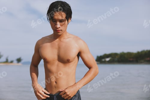 Preview: Sun-kissed Asian Man Tanning on a Tropical Beach, Enjoying the Freedom and Happiness of a Summer