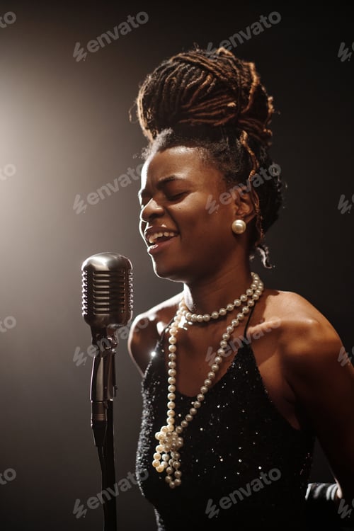 Preview: Young Black Woman Singing Jazz Music into Microphone under Stage Lighting