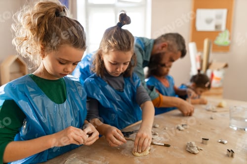 Preview: Group of little kids with teacher working with pottery clay during creative art and craft class at