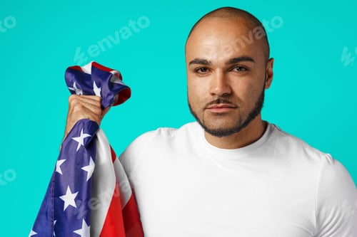Preview: Portrait of young dark-skinned man proudly holding USA flag