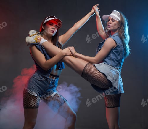 Preview: Two flexible femal e dancer posing in shiny smokey background