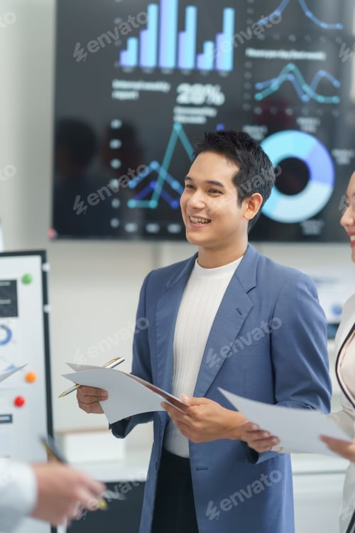 Preview: Asian businessman smiling during a meeting presenting financial data