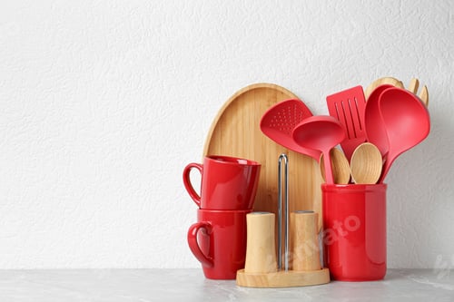 Preview: Set of kitchen utensils in stand on stone table near light wall. Space for text