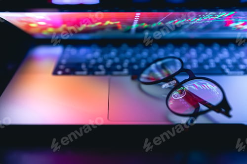 Preview: Close up of laptop keyboard colorful neon illumination and eyeglasses.