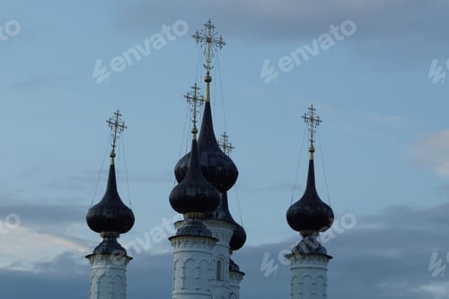 Preview: Multiple pointed-roof buildings featuring spires silhouetted against a cloudy sky