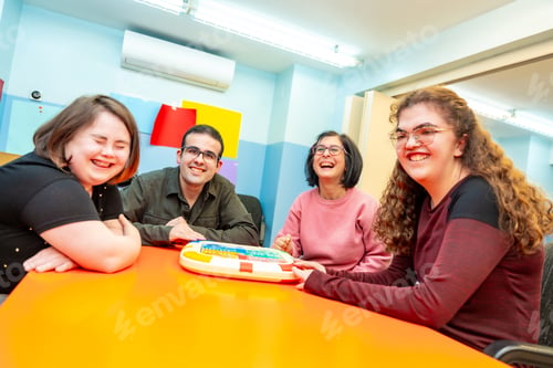 Preview: Portrait of happy disabled people playing board games