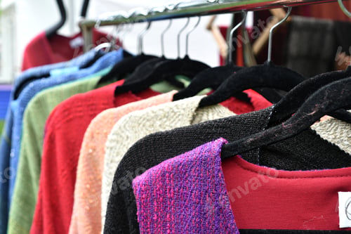 Preview: Preowned clothes hanging on hangers at a thrift store, used clothing