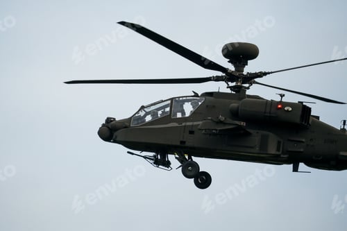 Preview: Dark grey army attack helicopter in flight during the daytime