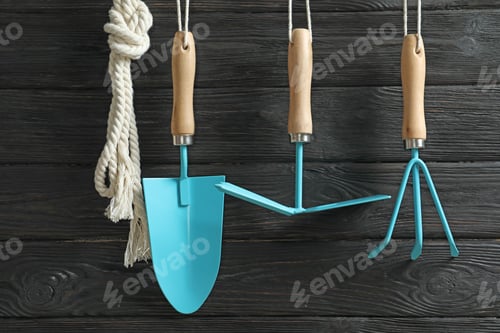 Preview: Set of professional gardening tools hanging on wooden wall