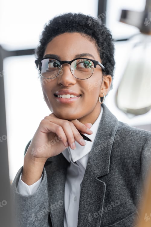 Preview: portrait of happy and successful african american businesswoman in stylish eyeglasses looking away