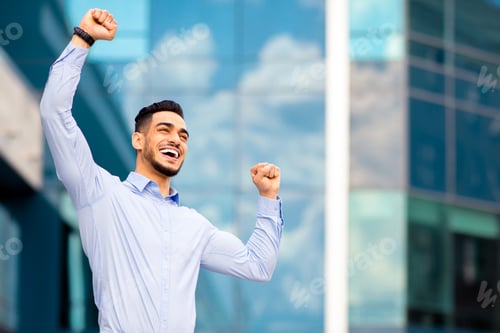 Preview: Emotional arab guy in formal outfit raising hands up