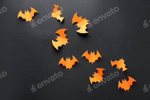 Preview: Halloween decor. Orange paper bats on black background, flat lay