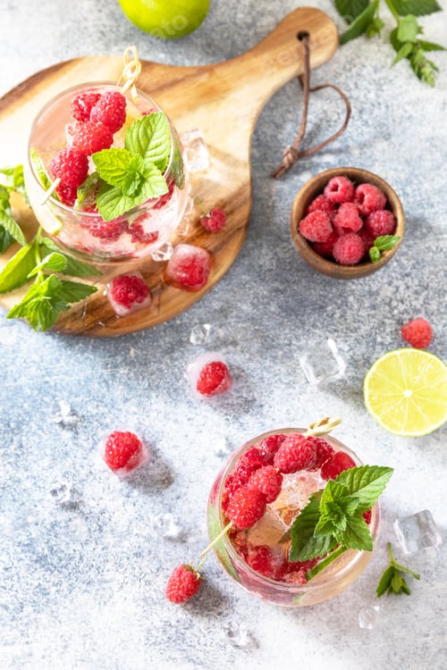 Preview: Hard seltzer cocktail with raspberries and lime on a gray stone table