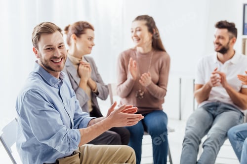 Preview: group of people smiling and applauding during support group session