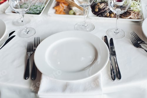 Preview: Close-up empty serving white big plate surrounded by knife fork ready to eating food high angle
