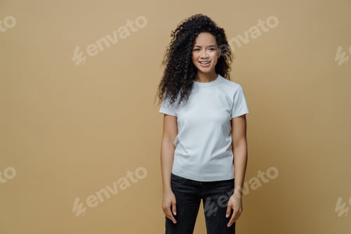 Preview: attractive cheerful woman with Afro hairstyle smiles positively, rejoices buying new clothes