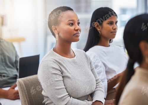 Preview: Shot of a young woman listening attentively in a meeting at working in modern