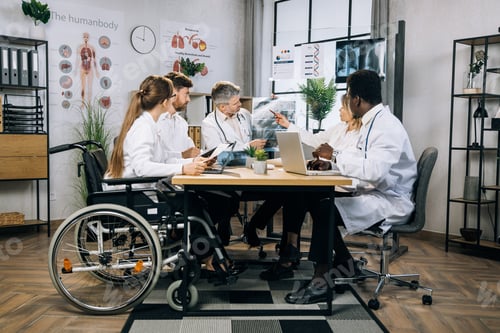 Preview: Mixed race medical workers discussing results of x ray scan