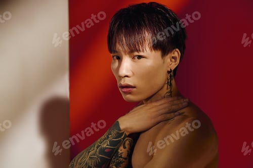 Preview: Stylish young man showcasing contemporary fashion in artistic lighting at a modern studio