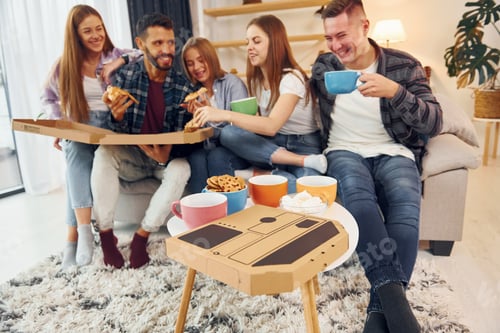 Preview: Eating food and drinking tea. Group of friends have party indoors together