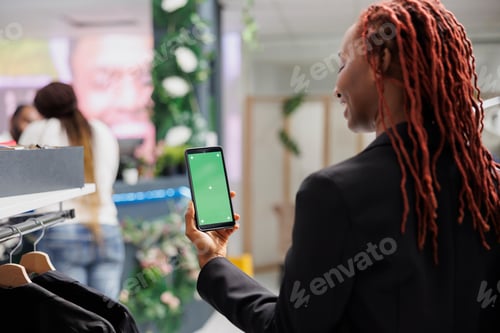Preview: Woman holding phone with green screen while shopping