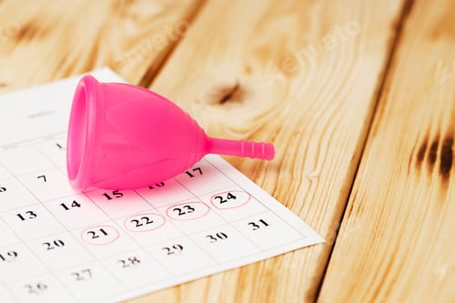 Preview: Calendar page and menstrual cup close up