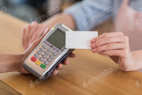 Preview: cropped shot of woman using credit card for payment in cafe