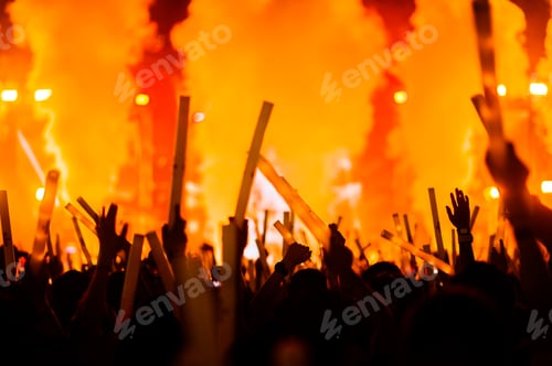 Preview: silhouettes of hand in concert.Light from the stage.confetti.the crowd of people silhouettes