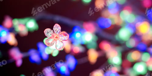Preview: Multicolored lights bokeh from decorative luminous flowers garlands at holiday, multicolored lights
