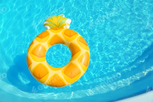 Preview: Bright inflatable pineapple ring floating in swimming pool on sunny day, above view. Space for text
