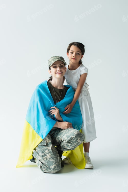 Preview: Kid hugging soldier in military uniform and ukrainian flag on grey background