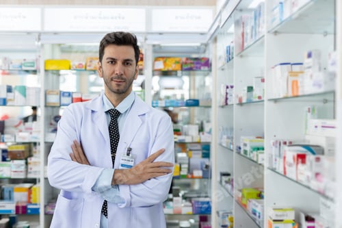 Preview: Portrait male charming smiling pharmacist arms crossed looking at camera.