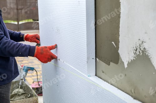 Preview: Construction worker installing styrofoam insulation sheets on house facade